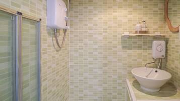 A bathroom with a shower, a sink, and a mirror.