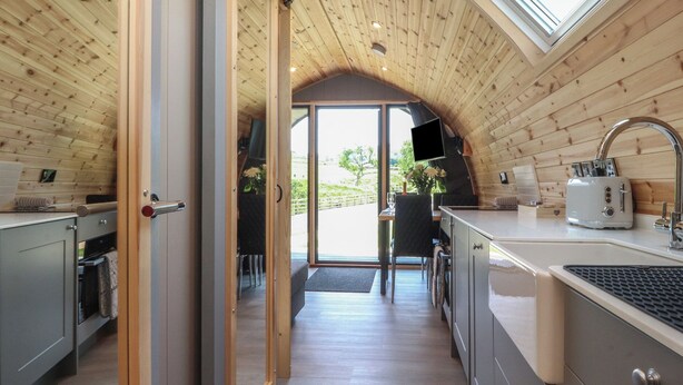 Una cucina accogliente con pareti in legno, un'ampia finestra e un lavello moderno.