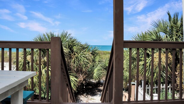 A wooden deck with a view of the ocean.