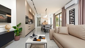 Una sala de estar moderna con un sofá, una mesa de centro y un comedor con sillas y una mesa.