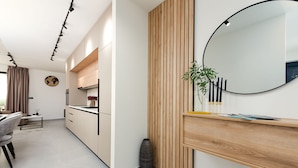 Una cocina moderna con armarios de madera, un espejo redondo y una planta en maceta.