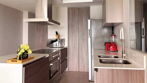 A modern kitchen with a built-in oven, microwave, and a red blender. - Panoramic City View I Near Colomos (Guadalajara)