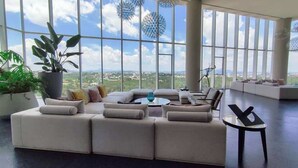 Ein geräumiger Wohnbereich mit einem großen Ecksofa, einem Couchtisch und Blick auf die Landschaft durch große Fenster.