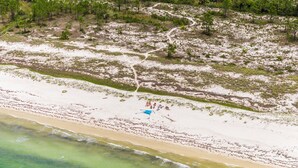 An aerial view of a beach with a clear path leading to the water, surrounded by sparse vegetation. - Fall Break, Family Friendly, Walk2Beach & Pools, Golf Cart, 4BR, 2 Kings (Port St. Joe)