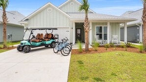 A residential house with a garage, a covered porch, and a driveway. - Fall Break, Family Friendly, Walk2Beach & Pools, Golf Cart, 4BR, 2 Kings (Port St. Joe)