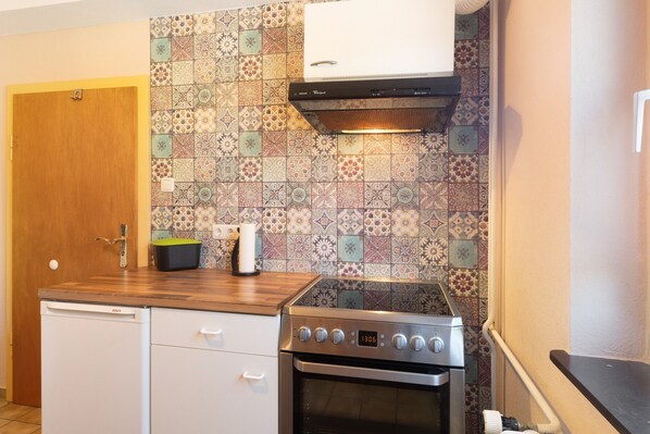 A kitchen with a Bosch dishwasher, a stove, and a patterned backsplash.