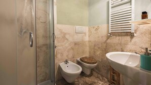 A bathroom with a shower, bidet, toilet, sink, and towel rack. - Romito Loft by MMega (Florence)