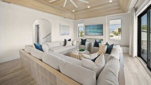 A modern living room with a sectional sofa, a coffee table, and a large window with a view.