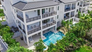 A multi-story hotel with a rooftop pool, outdoor seating, and lush landscaping. - New-Endless Amenities-Unmatched Rooftop & Views (Clearwater)