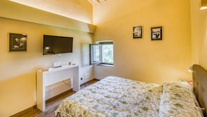 A bedroom with a bed, a TV mounted on the wall, a window, and a desk with a computer. - Romantic Apartment In Chianti Classico (Castelnuovo Berardenga)