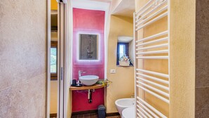 A modern bathroom with a pink accent wall, a white sink, and a toilet. - Romantic Apartment In Chianti Classico (Castelnuovo Berardenga)