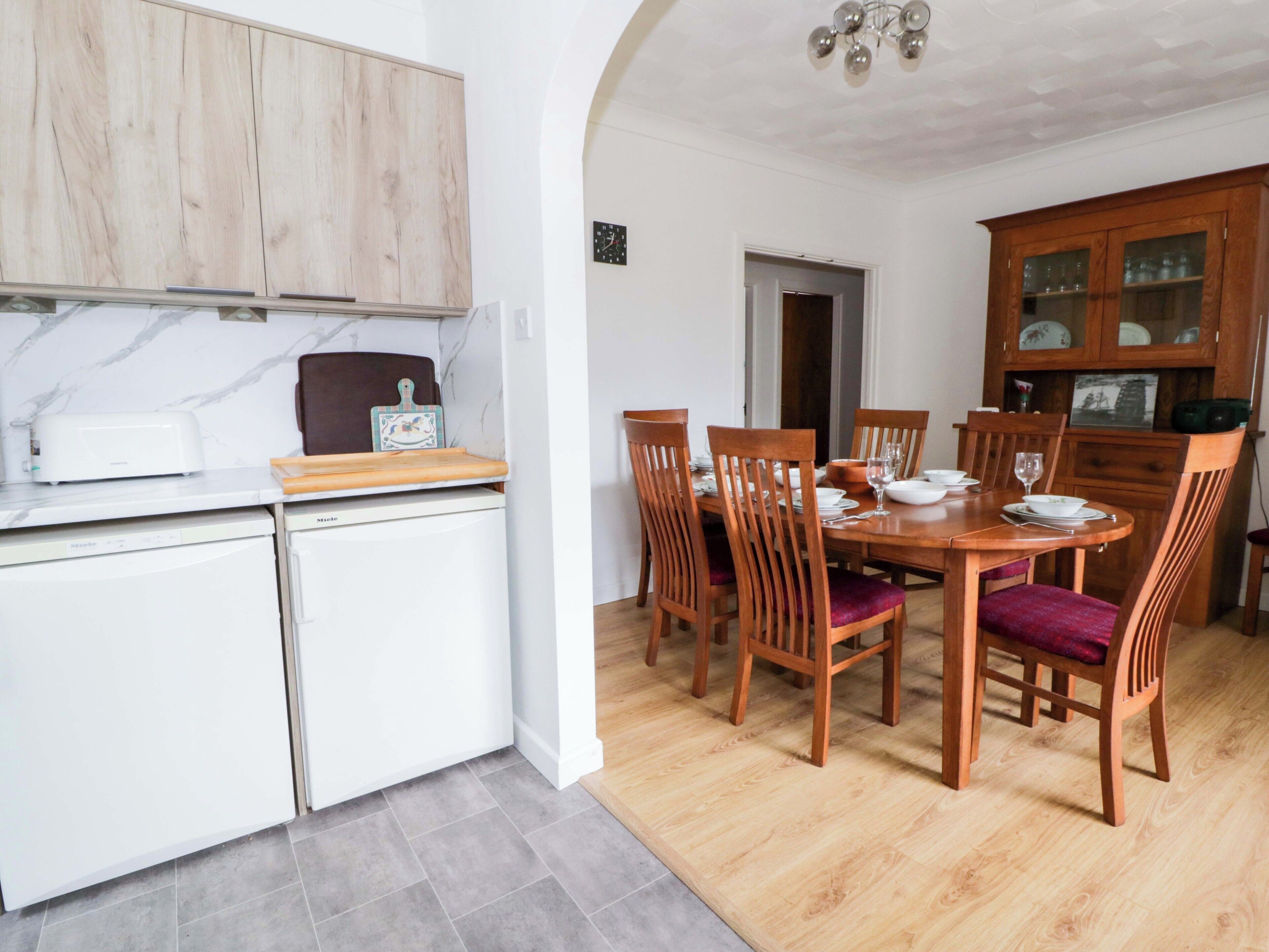Una cocina compacta con comedor, que incluye una mesa de madera, sillas y un mueble empotrado.