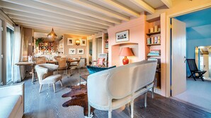 Un espacio habitable amplio con sofá, sillas, una mesa de comedor y una cocina al fondo.
