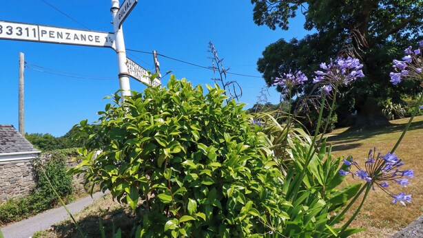 A street sign with directions to Penzance and a stone building with a stone roof. - Chyancrowse (Penzance)