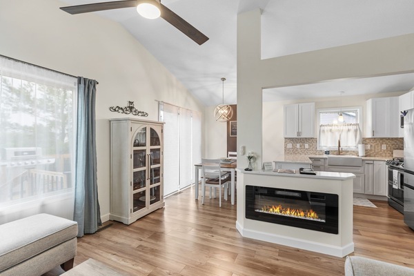 Step into your stunning open-plan retreat where warm hardwood floors lead to a chef's kitchen with gleaming countertops and cozy fireplace ambiance.