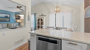 A modern kitchen with a central island, white cabinetry, and a ceiling fan. - MINNeSTAY* Meadows Retreat (Saint Michael)