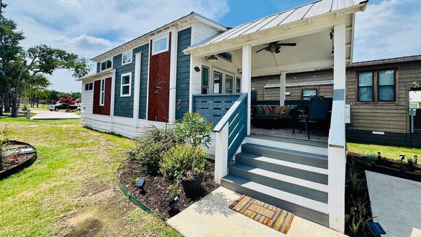 A two-story house with a covered porch, a staircase, and a patio area. - The Little Lonestar with Pool & Hot Tub (Austin)
