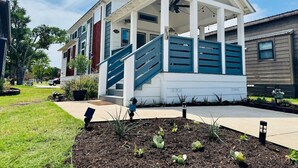 A two-story house with a covered porch and a blue staircase. - The Little Lonestar with Pool & Hot Tub (Austin)