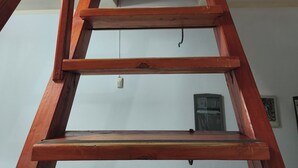 A wooden staircase with a handrail leading to a landing. - Nancy and Carlos's house, view of the mountains, swimming pool and barbecue area. (San Luis)