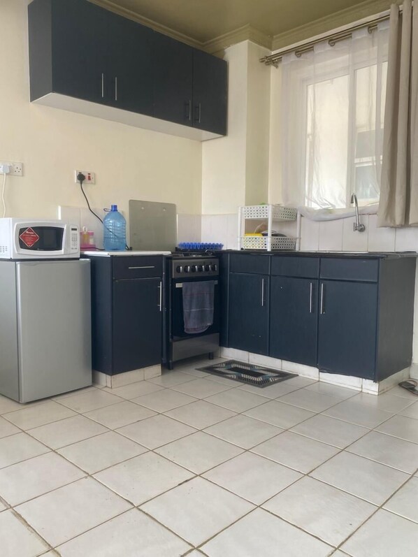 A compact kitchen with a microwave, stove, and cabinets.