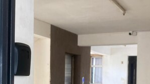 A corridor with tiled flooring, a door, and a wall-mounted intercom. - 5 minutes to Ngong hills! Family-sized condo with gym , supermarket $ school (Nairobi)