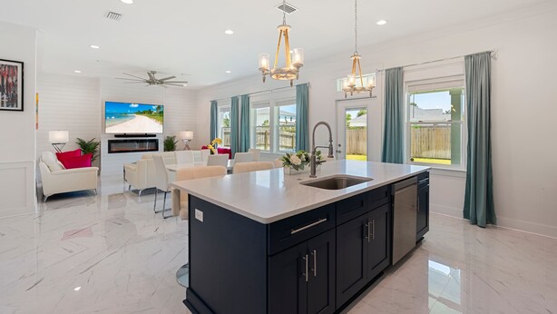 A modern kitchen with a central island, black cabinetry, and a large window with curtains. - Art Deco~Miami~Jacuzzi~Game Room~2 min. to Beach! (Panama City Beach)