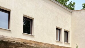 Une maison moderne dotée d’un patio entièrement vitré, d’une terrasse en bois et d’une piscine.