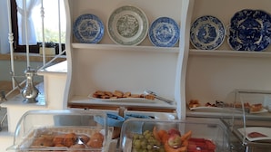 Ein reichhaltiges Buffet mit verschiedenen Speisen und dekorativen Tellern auf Regalen.