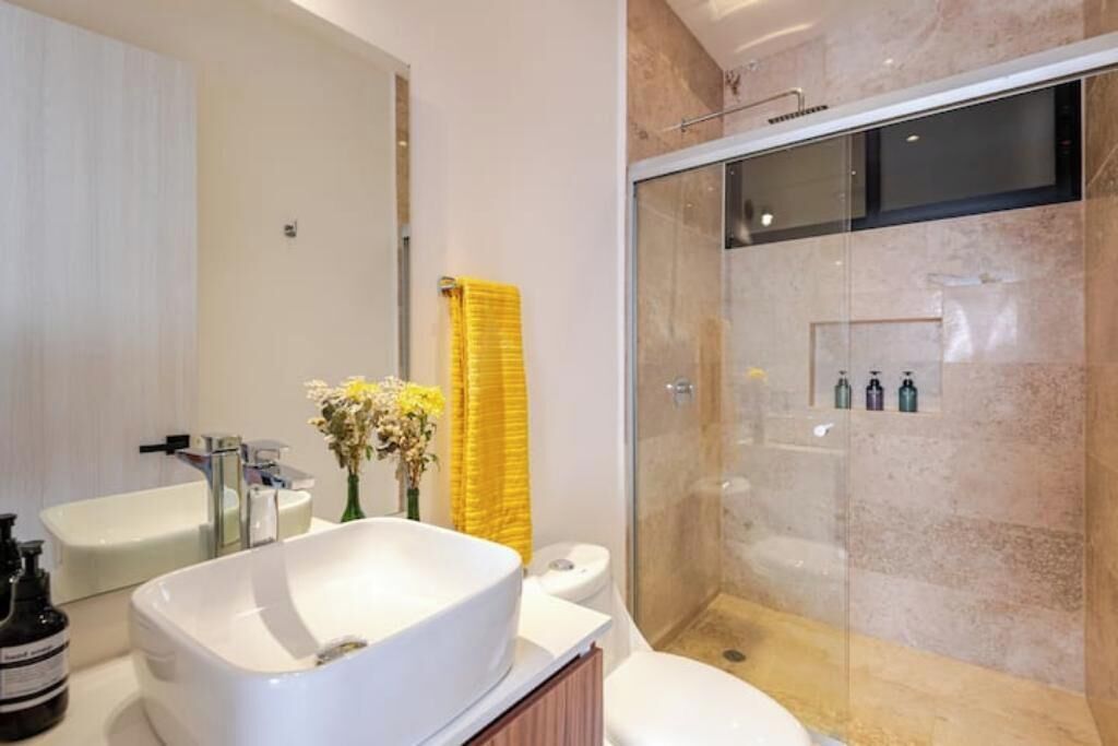 Un bagno moderno con una vasca da bagno indipendente, una doccia vetrata e un water.