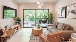 A modern living room with a sofa, coffee table, and TV mounted on the wall.