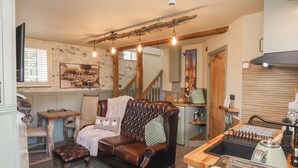 A cozy living room with a leather sofa, a wooden coffee table, and a vintage toaster. - Driftwood (Bridlington)