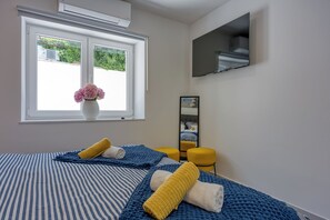 Ein Hotelzimmer mit Bett, einem Fenster mit Blick, einem Flachbildfernseher und einem Spiegel.