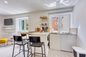 Una cocina moderna con comedor, televisor y vistas al exterior.