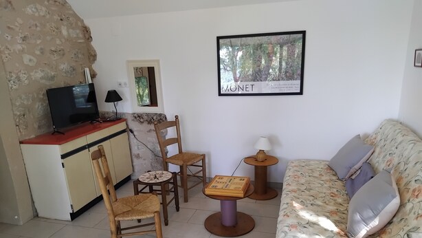 A living room with a sofa, chairs, a small table, a TV, and a framed picture on the wall. - PAULAGITE for 2 to 4 people, view of the Dordogne, near Padirac and Rocamadour (Gintrac)