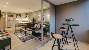 Una sala de estar moderna con un sofá, una mesita de centro y una pequeña zona de comedor.