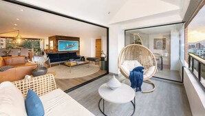 A modern living room with a sofa, a chair, a coffee table, and a TV. - |EP| Premium PH W/Sauna, Jacuzzi, SteamRoom (Medellín)