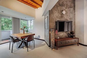 Ein modernes Interieur mit einem Holzespeisetisch, Stühlen, einer Bank und einem Kamin.