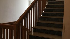 A staircase with wooden railings and dark marble steps. - Hotel Criss (Rimini)
