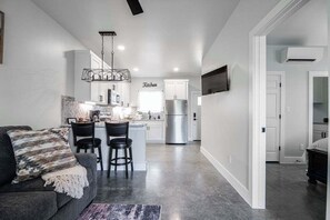 A modern kitchen with white cabinets, a stainless steel refrigerator, and a bar area. - Pet Friendly w/Hot-Tub-Six Minutes to Downtown! (Fredericksburg)