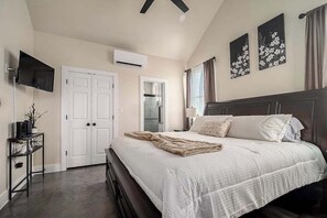 A bedroom with a bed, a TV, a desk, and a wardrobe. - Pet Friendly w/Hot-Tub-Six Minutes to Downtown! (Fredericksburg)