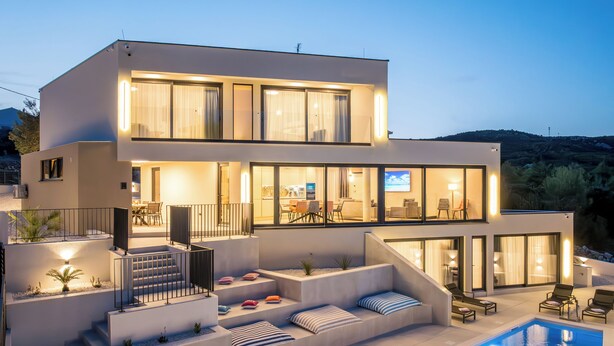 A modern two-story house with a swimming pool, outdoor seating, and a well-lit interior. - Mar Escape Designer Villa Croatia w/Sea Views, Private Pool, 4 En-Suite Bedrooms (Vinišće)