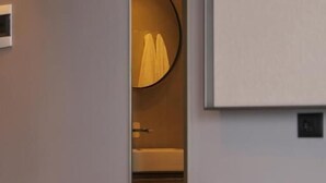 Een moderne badkamer met toilet, wastafel en spiegel.