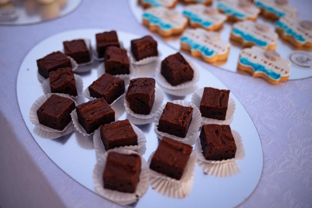 Un plato de brownies y galletas decoradas sobre una mesa.