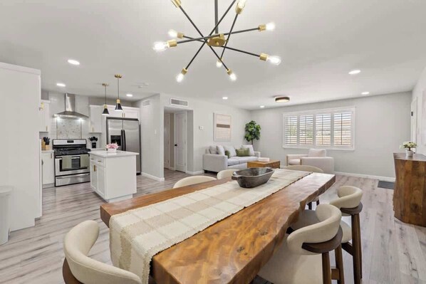 A modern kitchen with white cabinets, stainless steel appliances, and a central island.