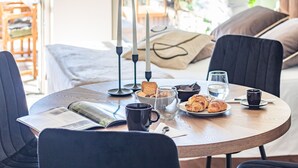 A breakfast table with croissants, a coffee cup, a glass of water, and a newspaper. - Aurora Apartment in Como (Como)