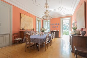 Ein Esszimmer mit einem großen Tisch, Stühlen und einer Kronleuchter.