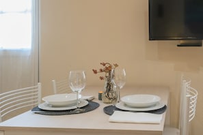 A dining table set with plates, glasses, and a vase with flowers. - Domus 3 in Como in Como (Como)