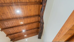 Techo de madera con vigas a la vista e iluminación empotrada.