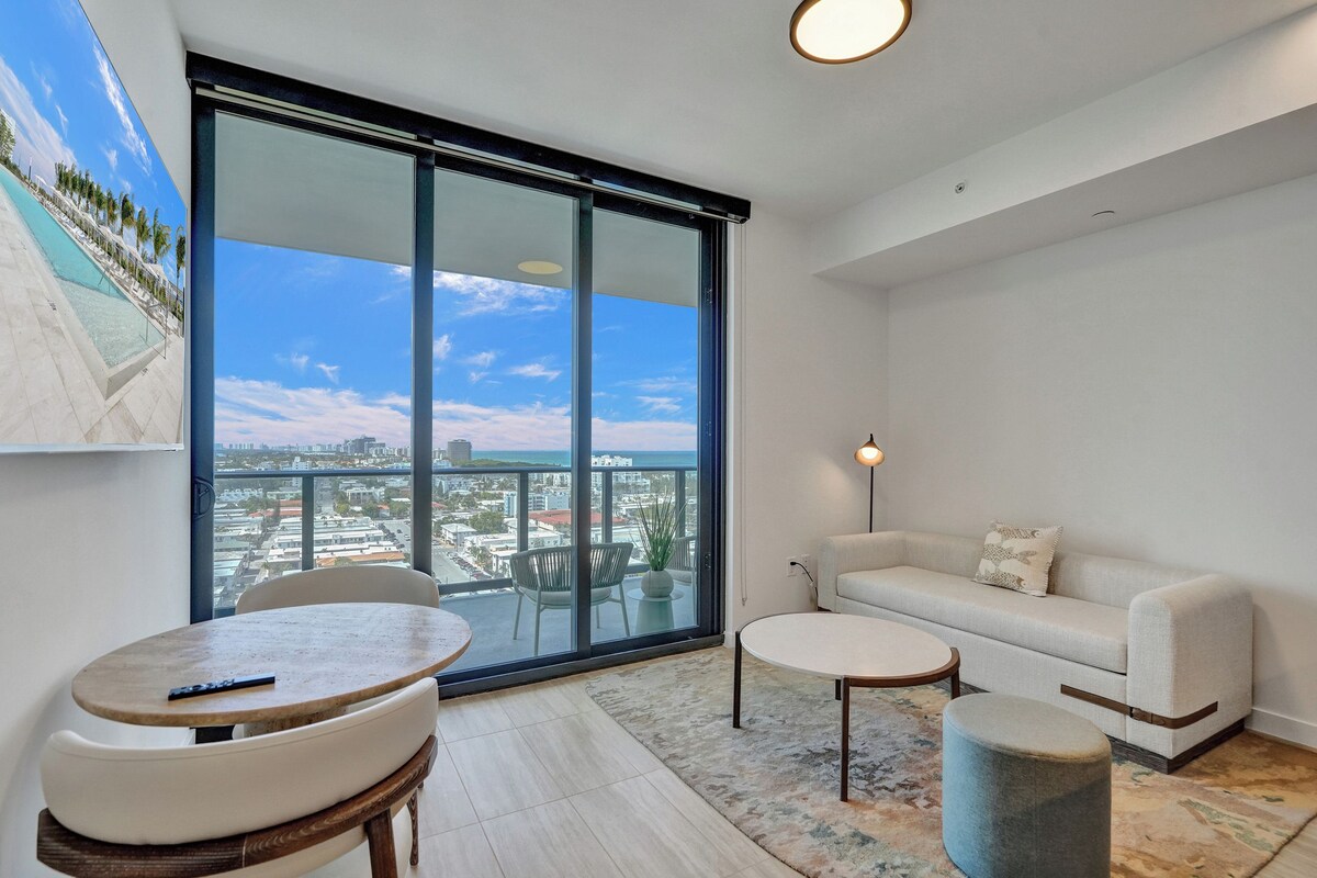 A balcony with a city view, a sofa, a table, and a chair.