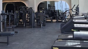 A gym with multiple treadmills, weight machines, and hanging pendant lights. - Miami 72 Building - 360-degree Views - We host (Miami Beach)